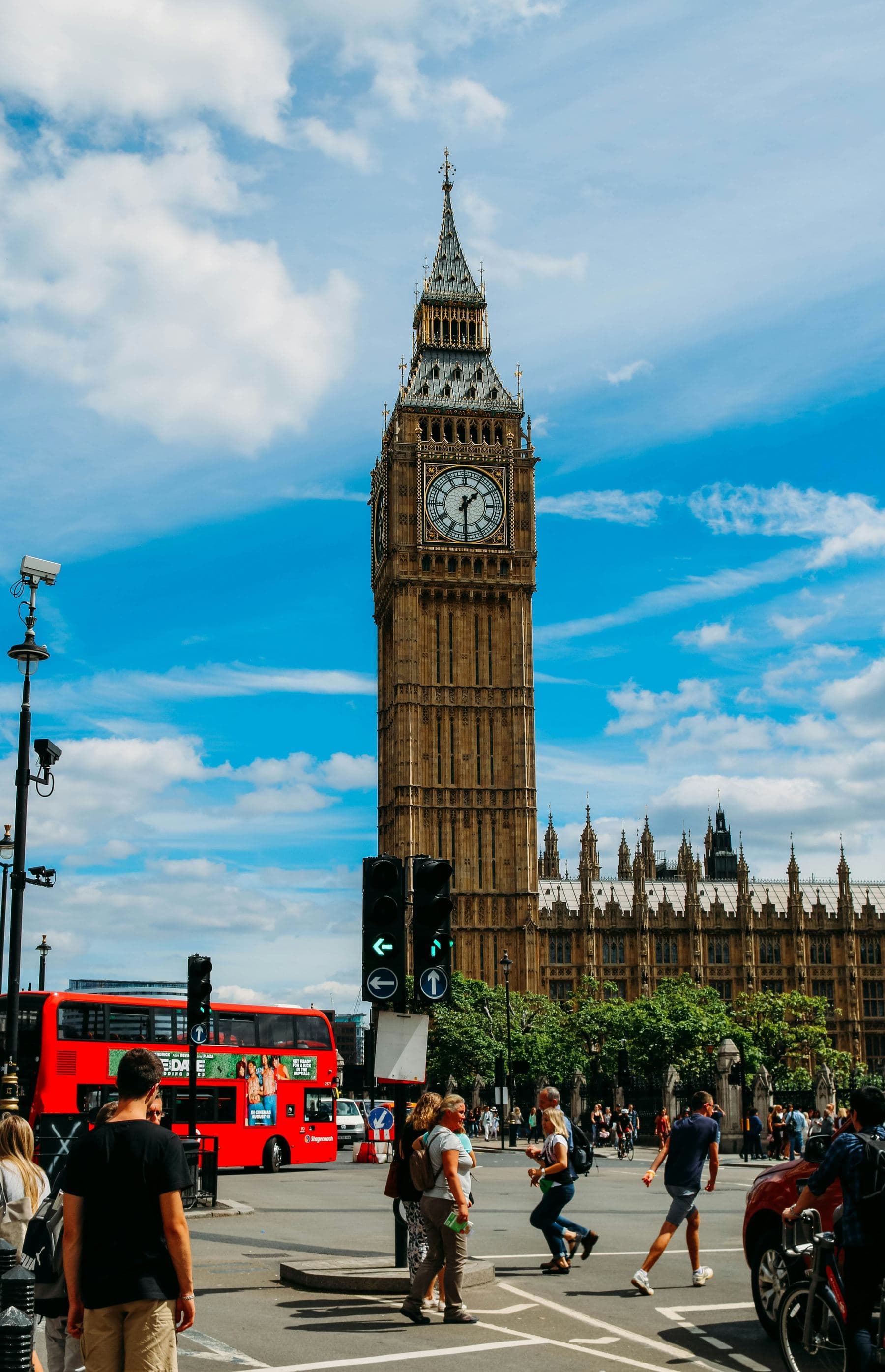 Londra’da aydınlık bir günde Big Ben ve Parlamento Binasının önünden geçen kırmızı çift katlı otobüs.