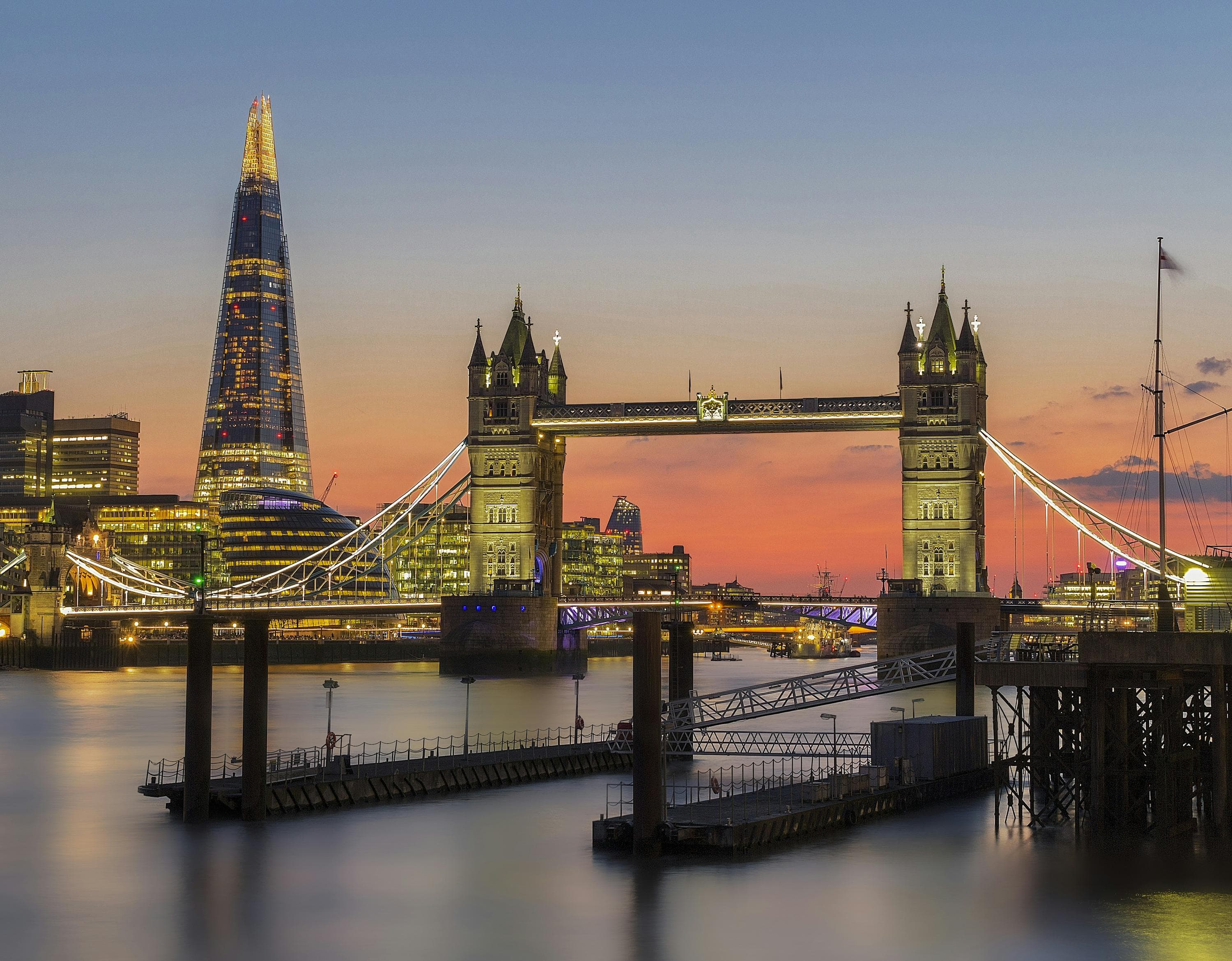 Tower Bridge and the Shard against a warm sunset sky over the Thames.