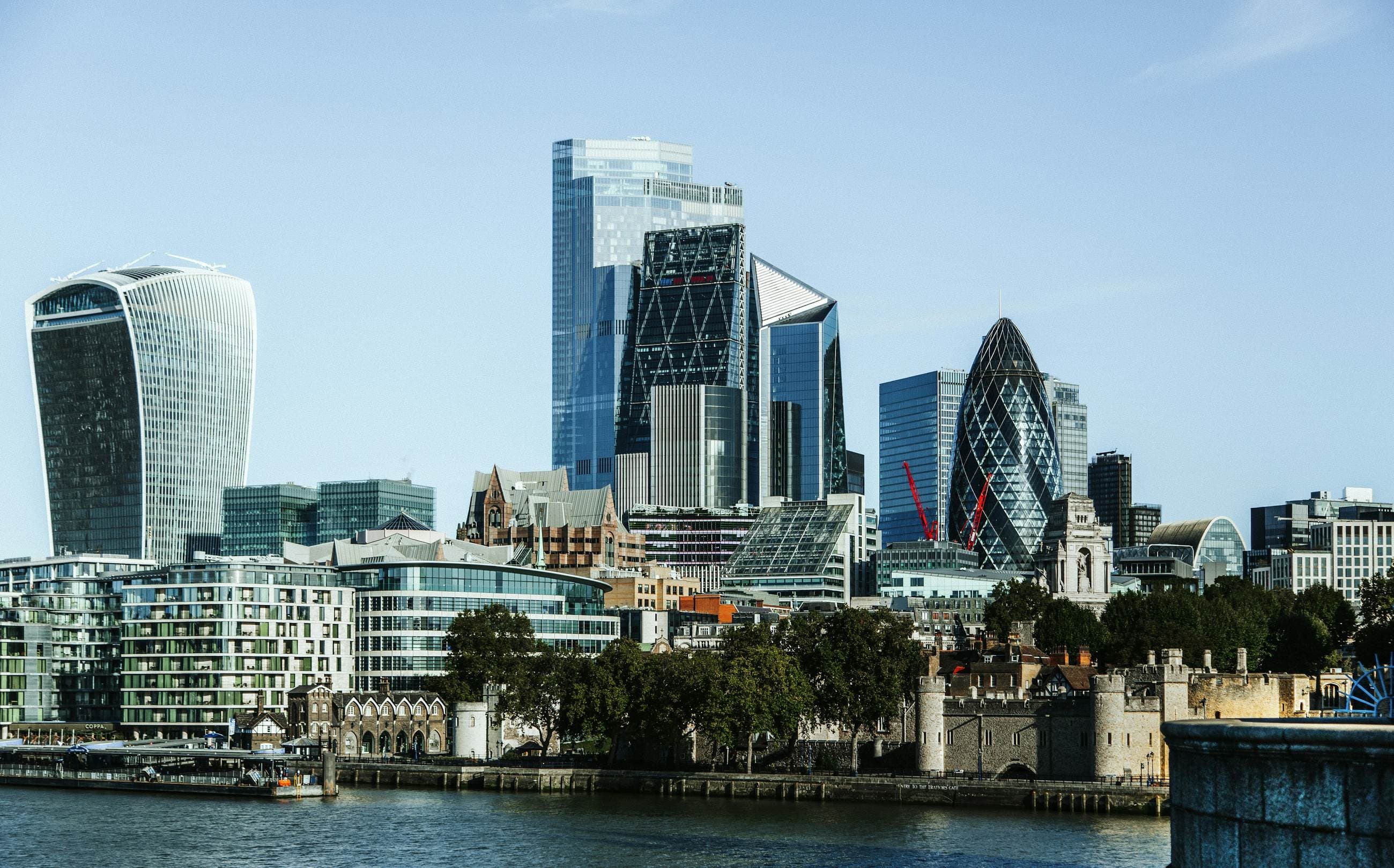 The towers of the City of London rising above the Thames in clear daylight.